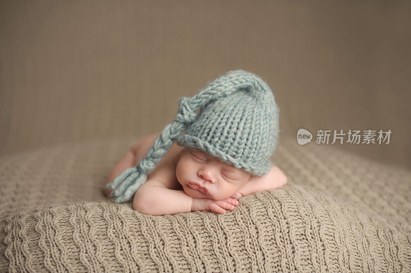 一个戴着针织帽睡觉的早产儿