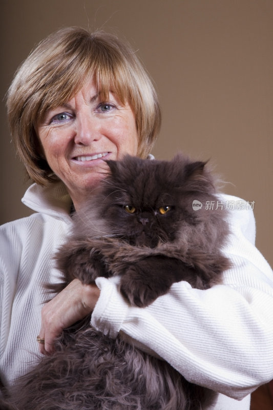 成熟的女人抱着一只波斯猫