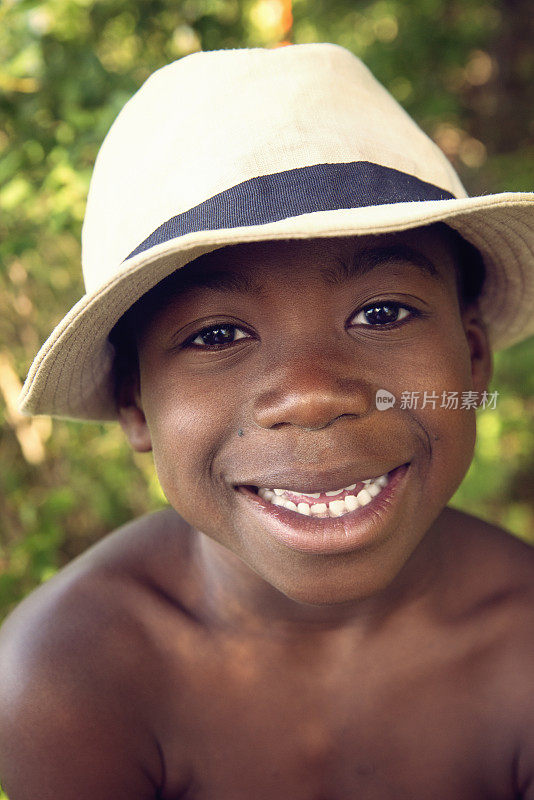 戴着帽子的非洲裔美国小男孩在大自然中摆姿势。