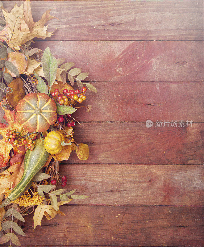 秋天的感恩节南瓜花环挂在古朴的木门上