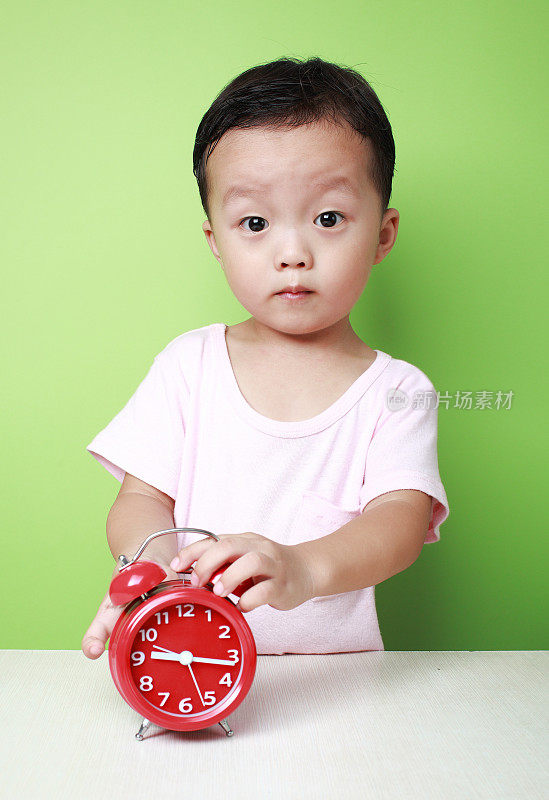可爱的亚洲小孩和时钟