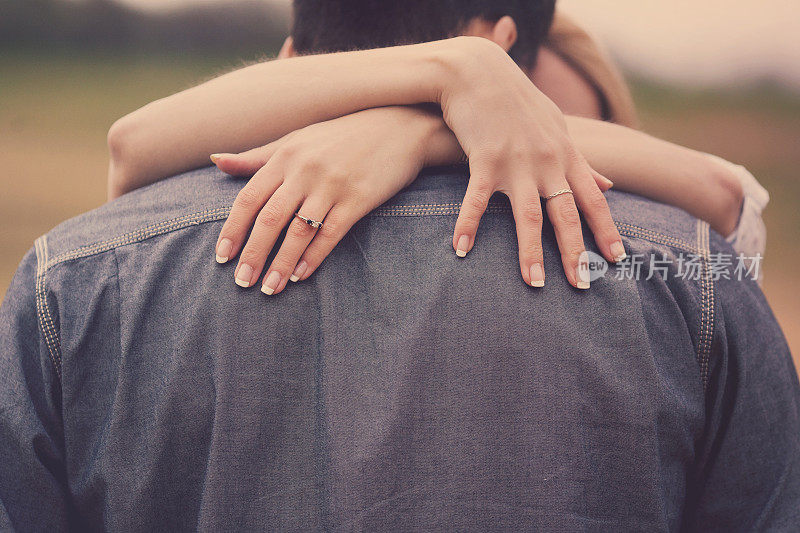 夫妇拥抱手在肩膀上与戒指