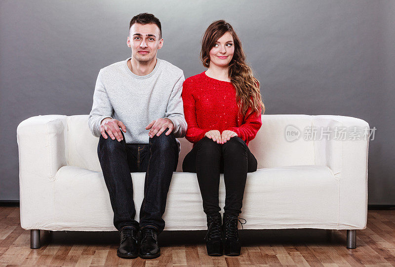 害羞的女人和男人坐在沙发上。第一次约会。