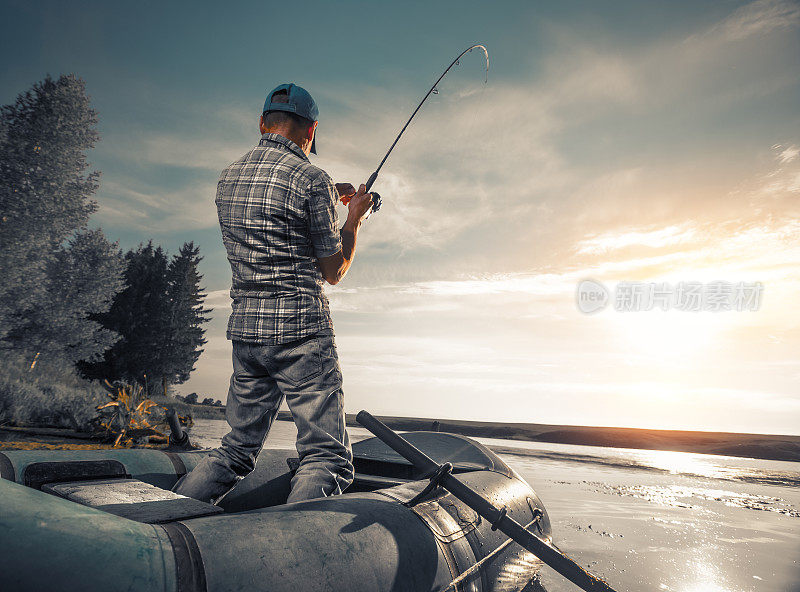 成熟的男人在湖边钓鱼
