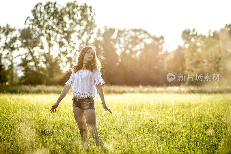 十几岁的女孩站在草地上伸开双臂