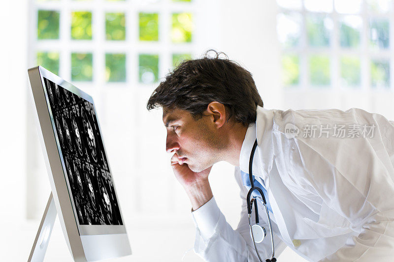 容男医生正在看人体腹部的CAT扫描图像