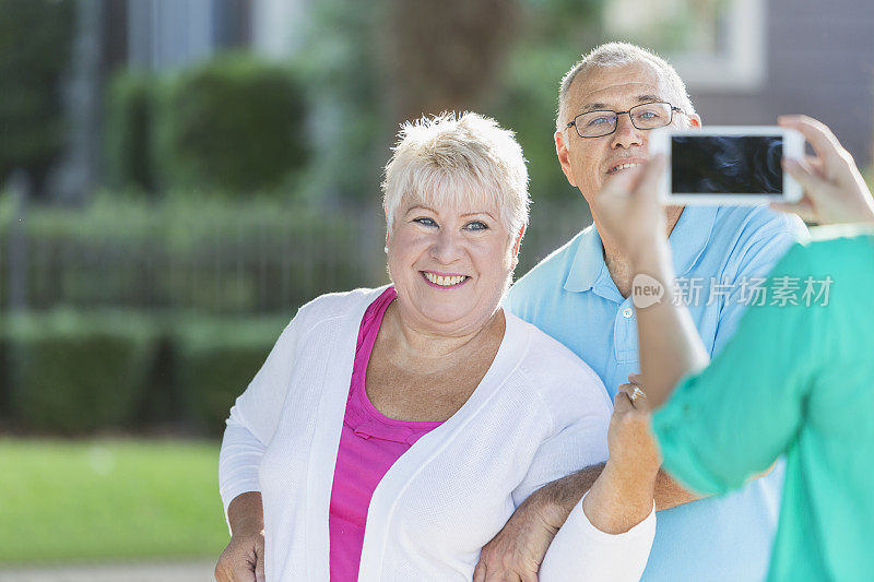 一对老年夫妇用手机拍照