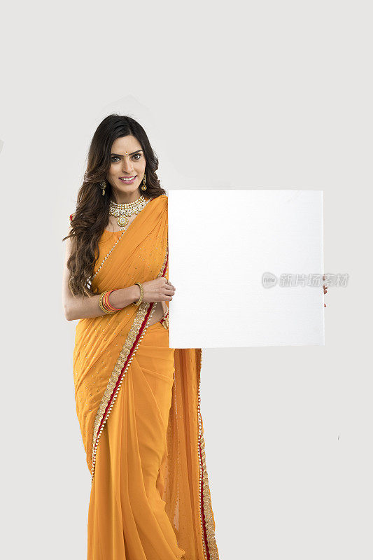 一个印度女人拿着一块空白的广告牌