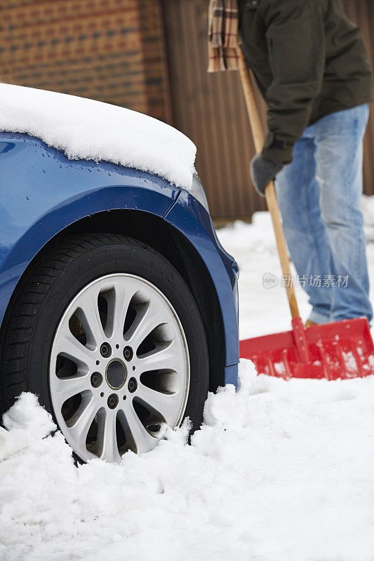 司机从雪中挖掘汽车