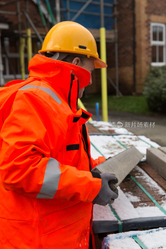 在英国房屋工地工作的男性建筑工人