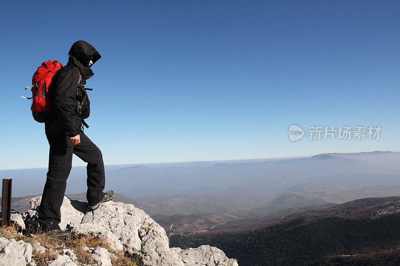 年轻的徒步旅行者站在山顶上