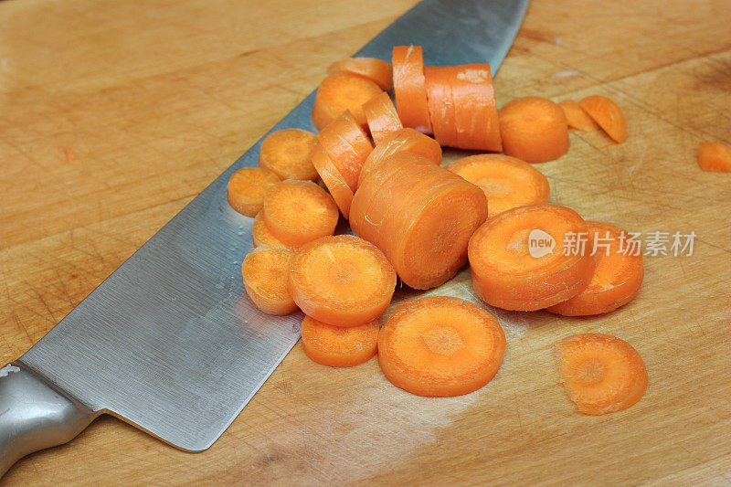 切碎的胡萝卜和一把刀的照片。