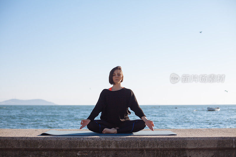 女人瑜伽放松在海边