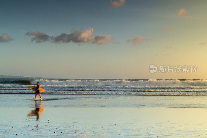 冲浪手带着冲浪板在海滩上行走