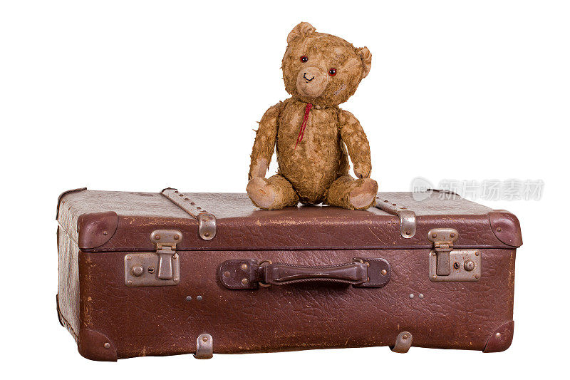 老泰迪熊坐在手提箱上