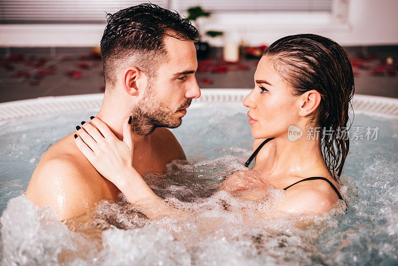 年轻迷人的夫妇在热水浴缸中放松