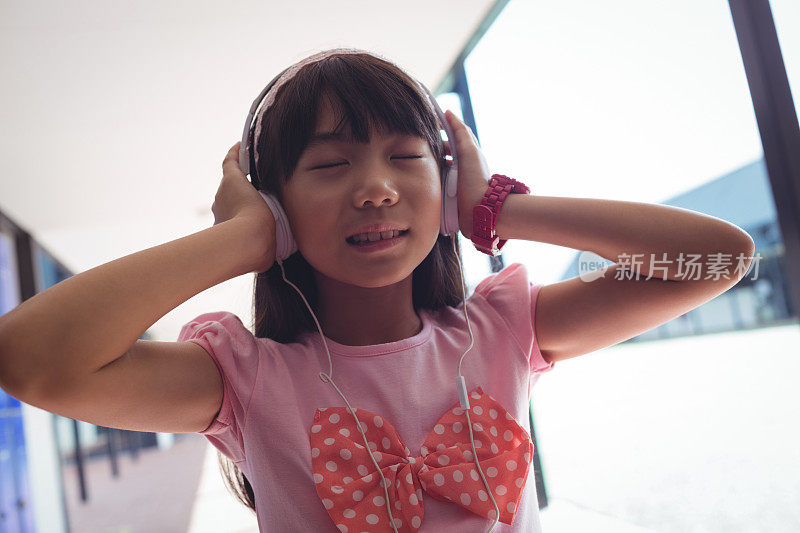 闭着眼睛戴着耳机听音乐的女孩