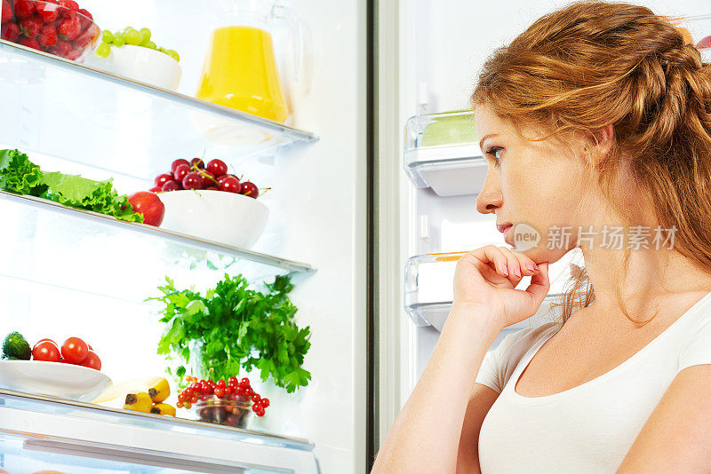 幸福的女人和他开冰箱吃水果、蔬菜
