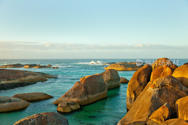 在澳大利亚西部，在太阳升起时，大象在海洋中岩石清晰的侧光