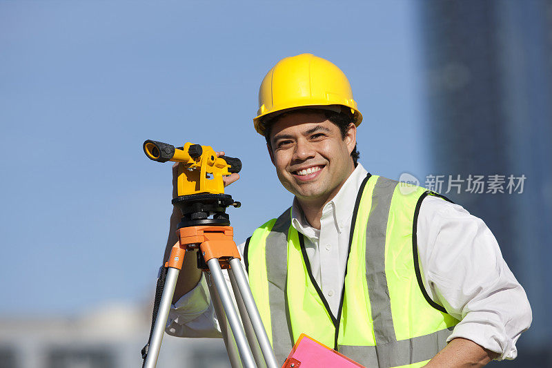 西班牙建筑工人戴安全帽和测量设备