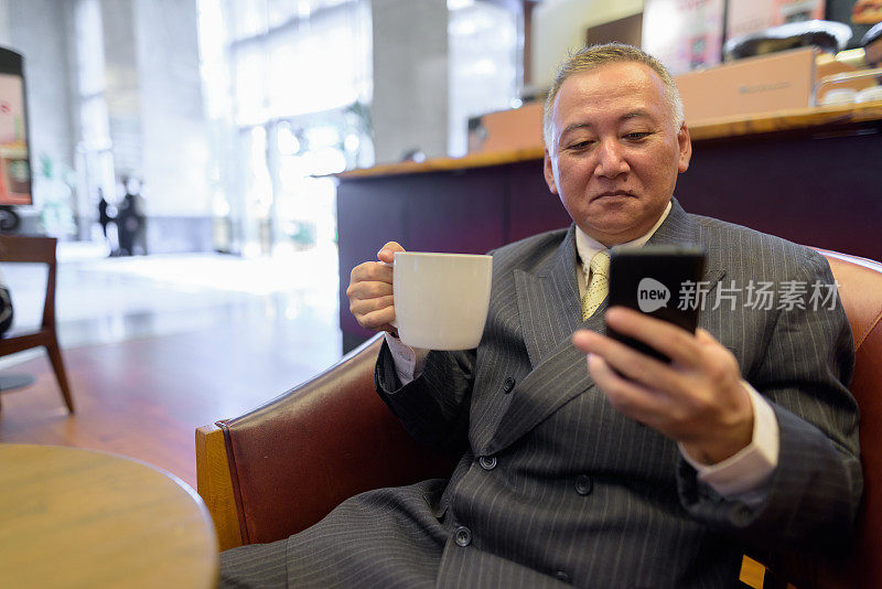 一幅成熟的亚洲商人在咖啡店休息的肖像