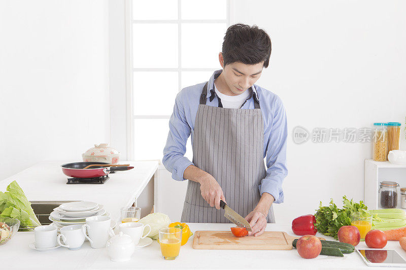 中年男人在厨房切蕃茄