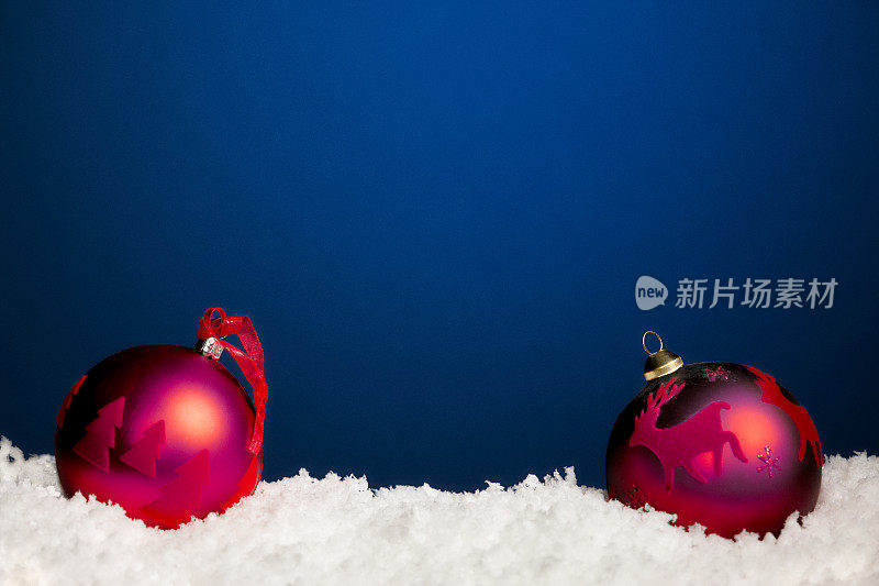 蓝色背景下的两个红色圣诞小玩意