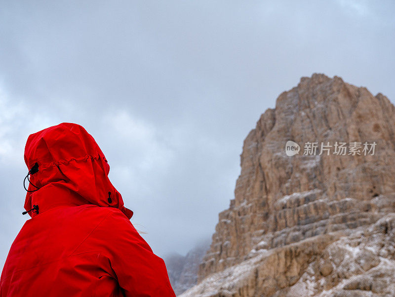 女性登山者在冬天观看高海拔的山峰