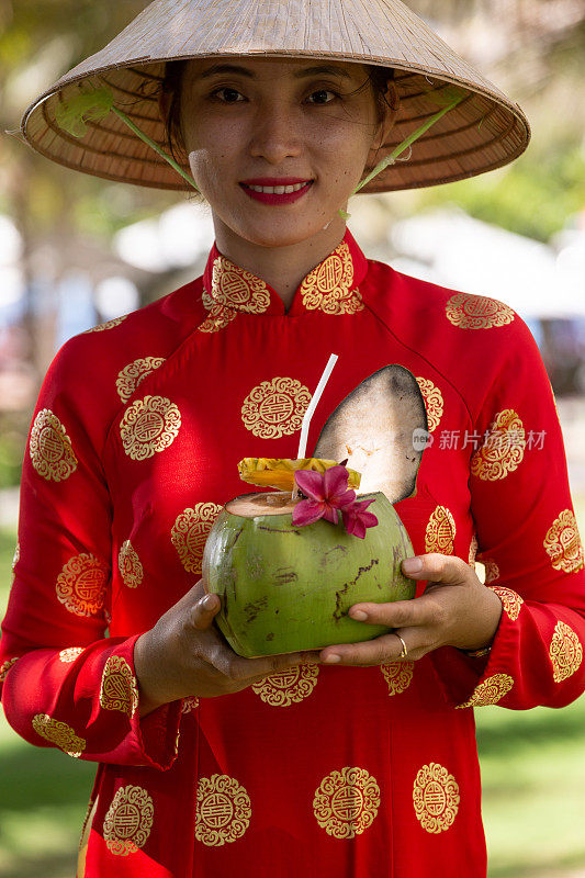 异国情调的传统越南女孩，同时提供新鲜的椰果和鲜花