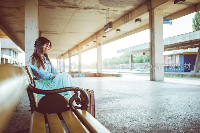 坐在长椅上等火车的女人。