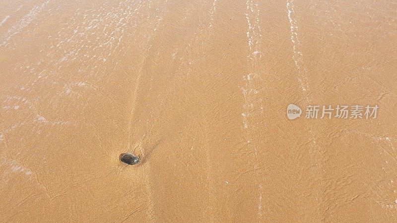 海水中的卵石在沙滩上激起泡沫