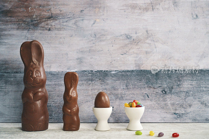 复活节装饰与巧克力兔子和复活节彩蛋在乡村背景