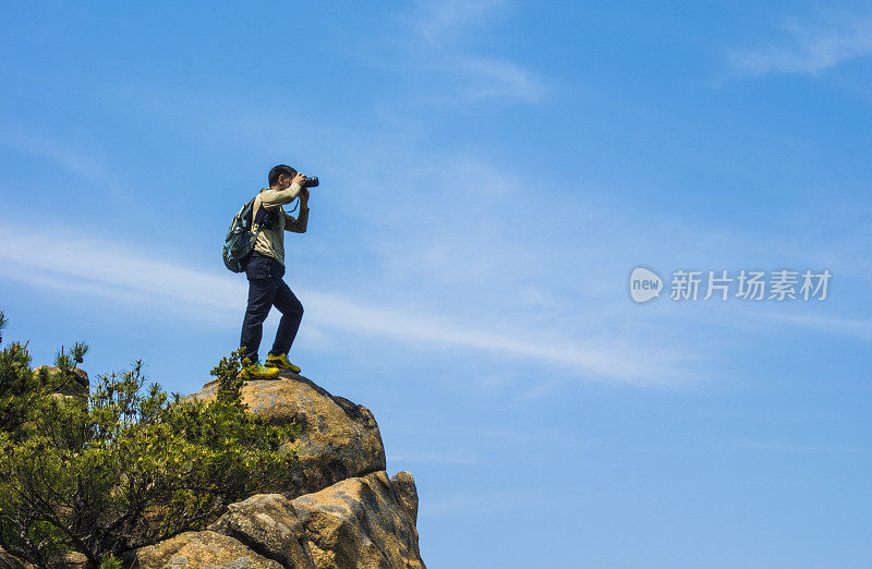 摄影师在岩石上拍照