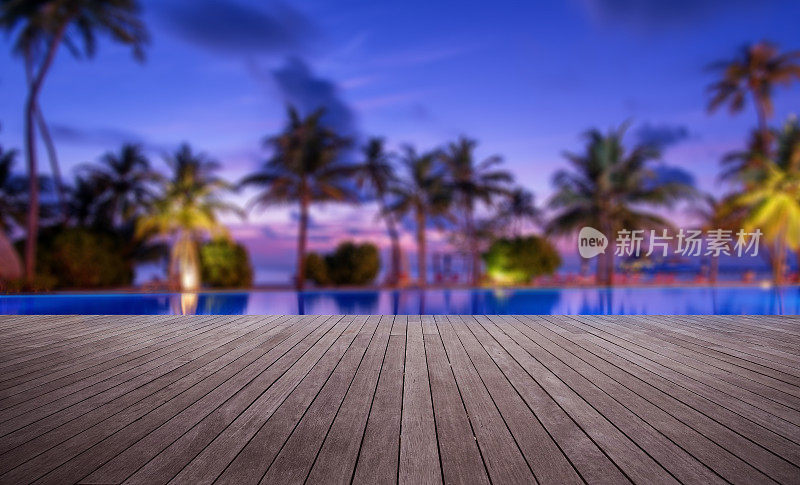 黄昏时分，热带海滩游泳池旁的木制露台
