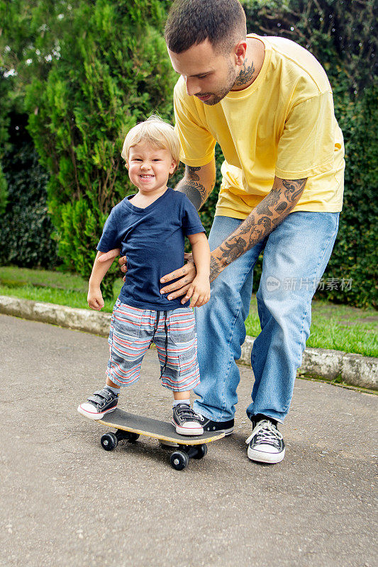 父亲在街上教儿子玩滑板