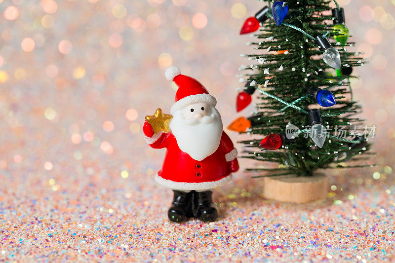 闪闪发光的背景与圣诞老人小雕像和微型圣诞树，闪闪发光的新年背景