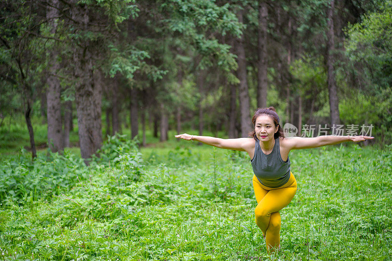 年轻的亚洲女人在森林里练习瑜伽