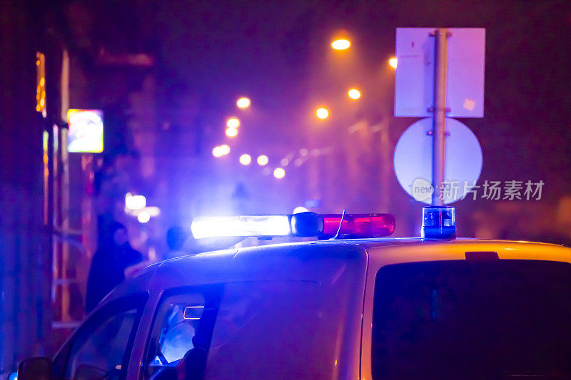 夜间在城市中闪烁着警灯的警车在行动。