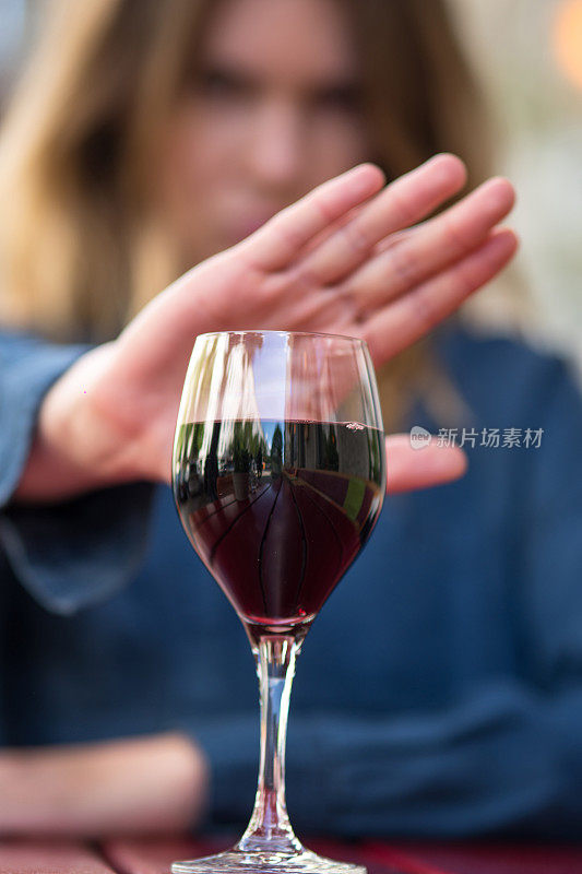 用手势拒绝喝葡萄酒或酒精饮料的女性。