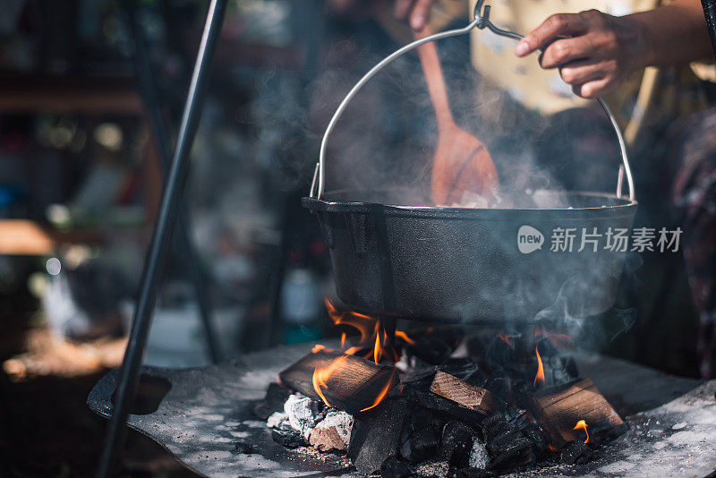 野外露营时在篝火上准备食物，野营旅行时在篝火上烹饪食物。野营厨房，在森林里烧食物。煎锅着火了。露营生活的概念。