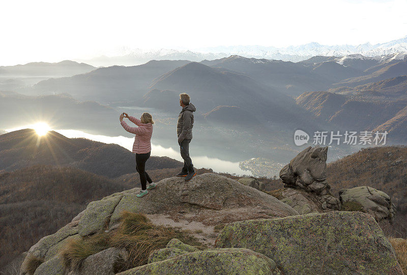 一对夫妇在湖上和山上拍摄日出