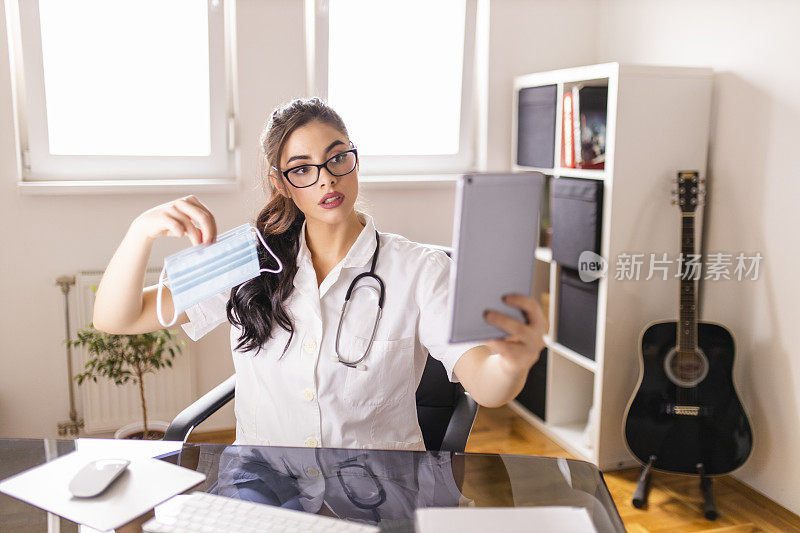 新冠肺炎大流行期间，年轻女医生在数字平板电脑上与患者视频通话