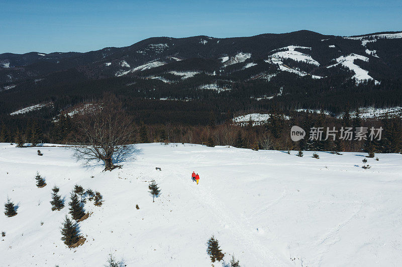 鸟瞰图的朋友旅行者做冬季徒步旅行的山与风景