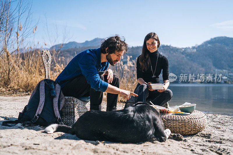 清晨，一对夫妇带着狗在湖边野餐