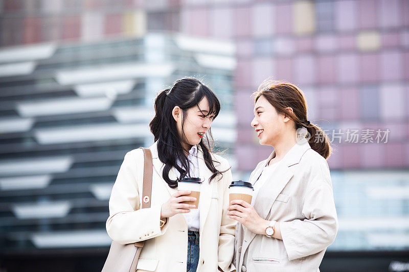 两个年轻女人在城市的街道上聊天