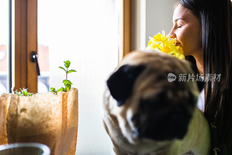 一个闻着花香的漂亮年轻女人