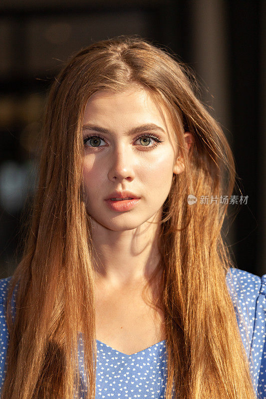 户外肖像，一个迷人的19岁女子，棕色长发，夏季蓝色连衣裙