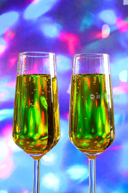 特写图像的香槟长笛包含起泡酒，干杯，葡萄酒杯庆祝祝酒词，照明仙光散景背景，聚焦前景