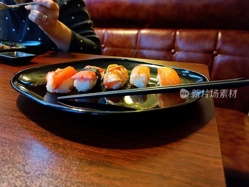 日本料理，日本寿司配红鱼。寿司酒吧。游客正在吃日本菜。