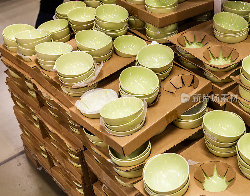 架子上排列着五颜六色的盘子和瓷碗。装饰餐具。